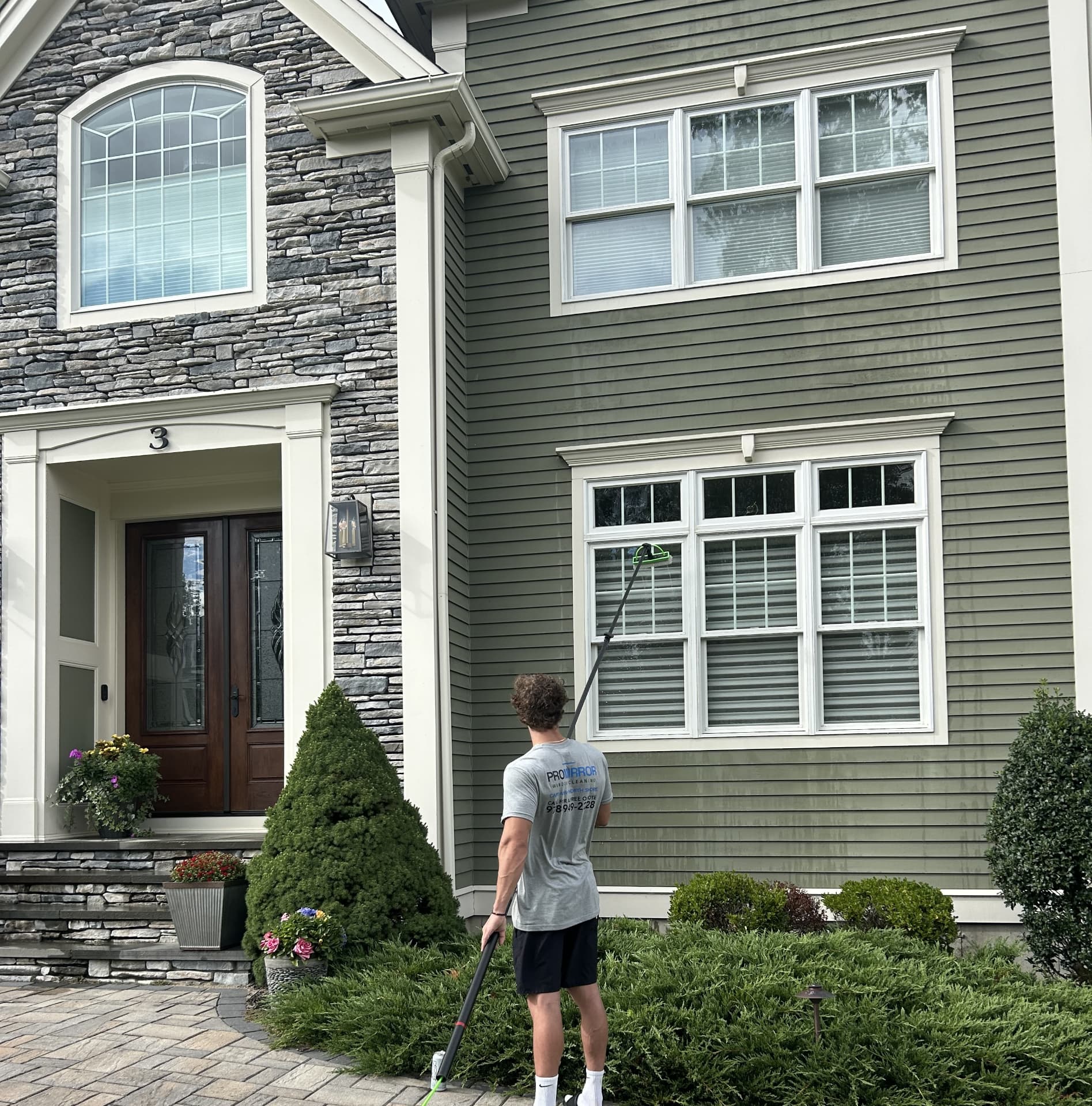 ProMirror technician cleaning windows on a North Shore home